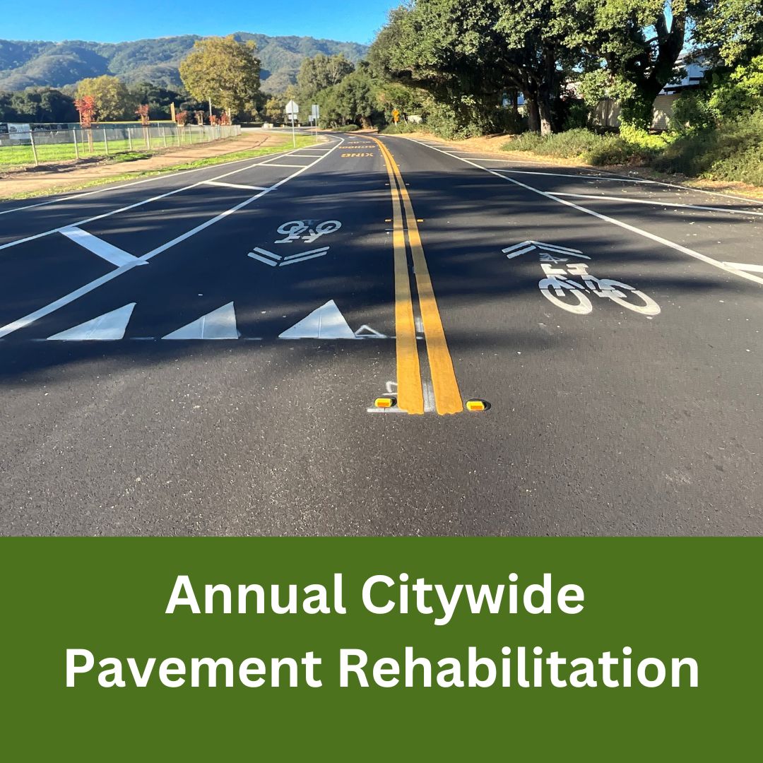 Freshly paved roadway with new lane striping, bike lane symbols, and directional arrows